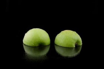 ein grüner Apfel in Scheiben geschnitten auf schwarzem