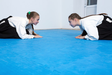 Two girls in black hakama bow on Aikido training
