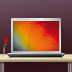 Laptop with polygonal screen background on office desktop