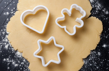 Various shaped cookie cutter on dough, preparing cookies