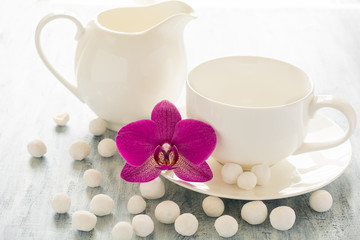 Empty dishes with orhid flower and white candies