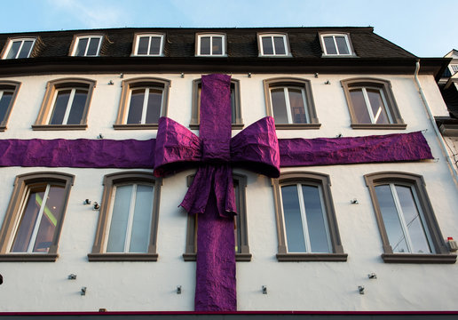 Violet huge ribbon on a building facade. Christmas time.