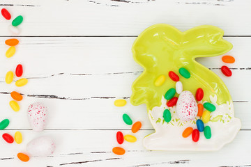 Chocolate Easter eggs over white rustic wooden background. Copy space