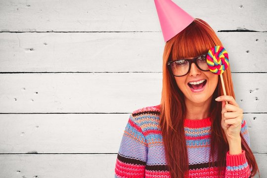 Composite image of smiling hipster woman with lollipop and hat