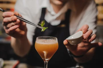 Fotobehang Barman decoreert cocktail met rucola © fesenko