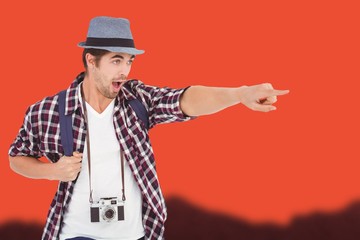 Composite image of surprised man with backpack pointing