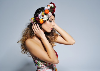 Beauty portrait of a gorgeous woman with gypsy hairstyle wearing handmade fairy flower crown .