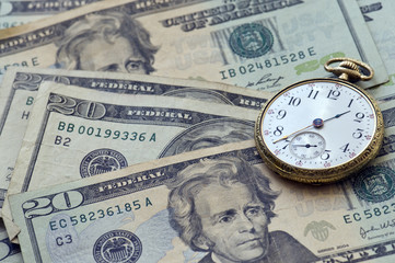 Time And Money. Old Pocket watch and US currency.