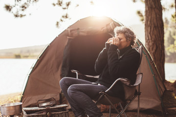 Mature woman at campsite drinking coffee