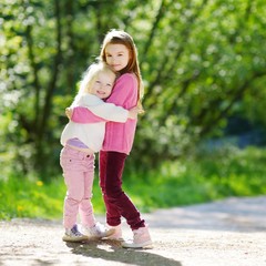 Fototapeta premium Two adorable little sisters laughing and hugging