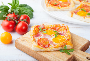 Fresh homemade square Pizza with vegetables and basil on cutting board