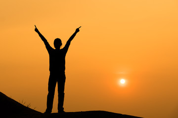 Fototapeta premium Silhouette of woman spreading hand to the sky