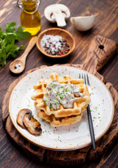 Savory waffles with corn and mushroom creamy sauce on a wooden background Top view