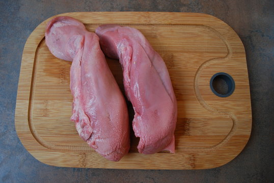 Pork tongue on a cutting board.