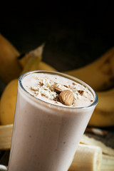Banana smoothie with milk, ground almonds in a large cup on the