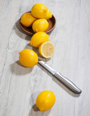 Slice lemon with knife on wooden background