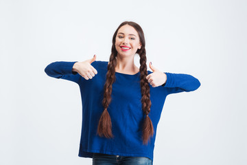 Beautiful happy woman with two braids showing thumbs up