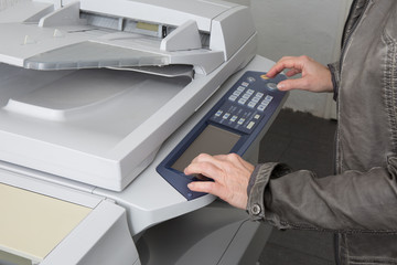 Woman's hand with a working copier at work