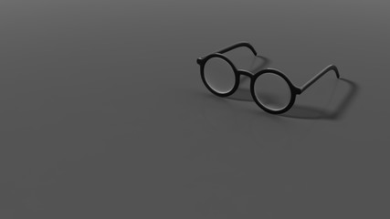 Pair of black round-lens eyeglasses, isolated on grey/black background.