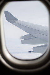 Wing of an airplane flying from porthole