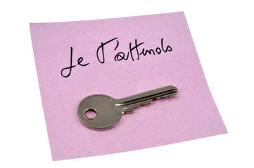 Je t'attends écrit sur une feuille avec une clé