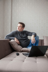 The man on a sofa with laptop