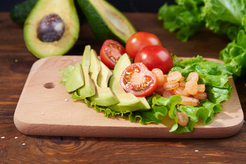 Vegetables and shrimps on a wooden background