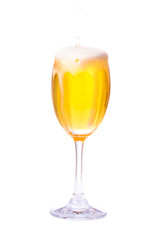 Beer spilling from glass on a white background.
