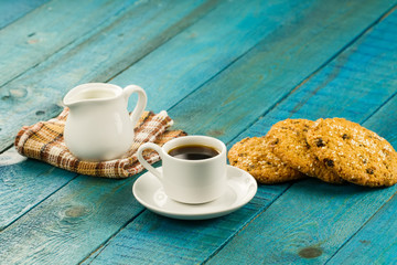 Chocolate chip cookies on an old vintage turquoise wooden background. Set table for breakfast. Hot Cup of coffee