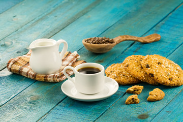 Chocolate chip cookies on an old vintage turquoise wooden background. Set table for breakfast. Hot Cup of coffee
