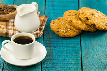 Chocolate chip cookies on an old vintage turquoise wooden background. Set table for breakfast. Hot Cup of coffee