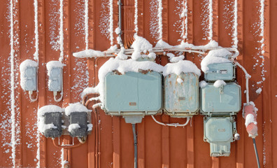 Electric junction boxes with snow, retro style on red wall
