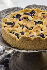 Blaubeerkuchen mit Lavendelblüten auf einer Kuchenplatte