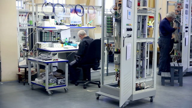 Workers builds electrical equipment, power transformer on a factory. Full HD.