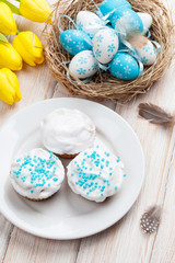 Easter with yellow tulips, colorful eggs and traditional cakes