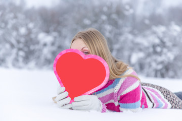 Young happy woman hiding behind red heart. Valentines day.