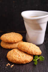 almond cookies on a black background with a cup of coffee
