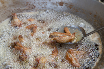 chicken deep frying in oil in a pan