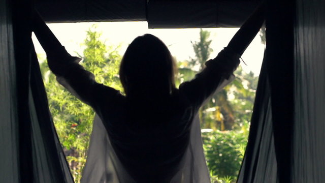 Woman unveil curtains and walking out on terrace, super slow motion 240fps 
