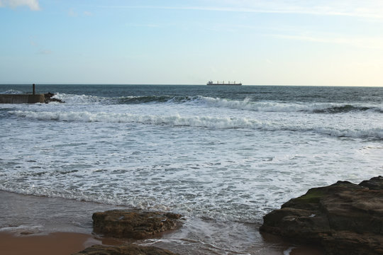 Sea coast and large ship on the horizon