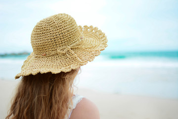 Frau mit Stohhut am Strand