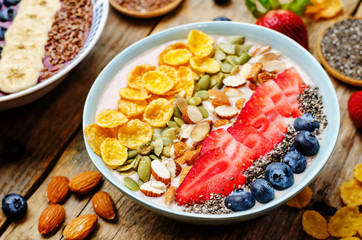 healthy strawberry smoothie bowl with fruits, cereals, seeds and