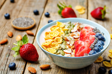 healthy strawberry smoothie bowl with fruits, cereals, seeds and