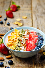 healthy strawberry smoothie bowl with fruits, cereals, seeds and
