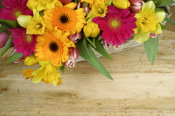 Multicolored bouquet spring flowers on wooden background