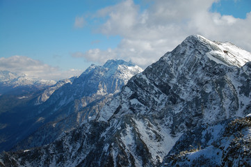 Fototapeta premium Beautiful snow-capped mountains against the blue sky, Panorama of mountain peaks with white clouds