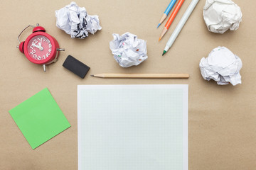 Business concept: post it,red clock,white blank paper,crumpled paper and color pencil,pencil,pen on brown paper background