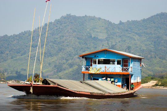 péniche et habitation bleu et rouge sur le Mékong, Laos