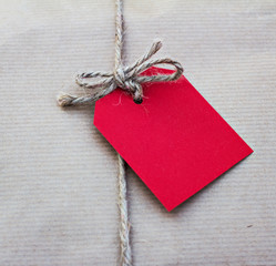gift in kraft paper with red card  on a wooden table