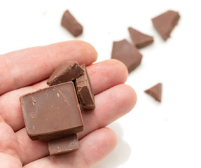 chocolate in his hand on a white background